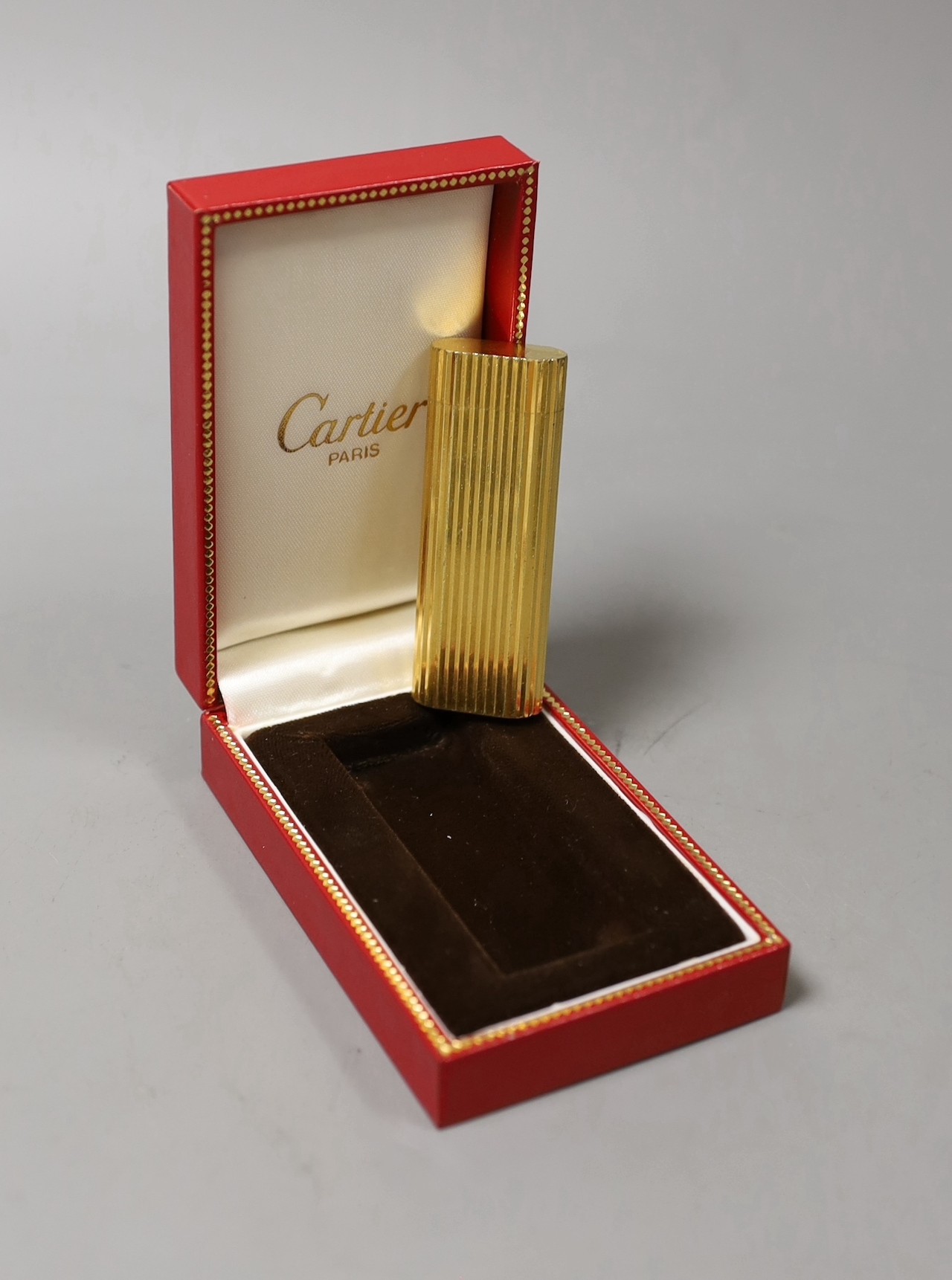 A Must de Cartier gold plated lighter, cased, 7cms long